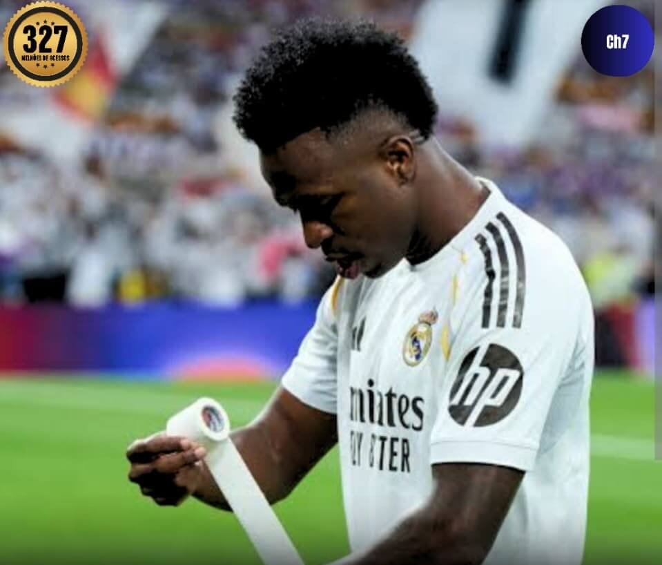 Vini Junior no campo enrolando uma faixa no braço