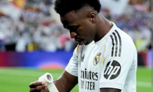 Vini Junior no campo enrolando uma faixa no braço